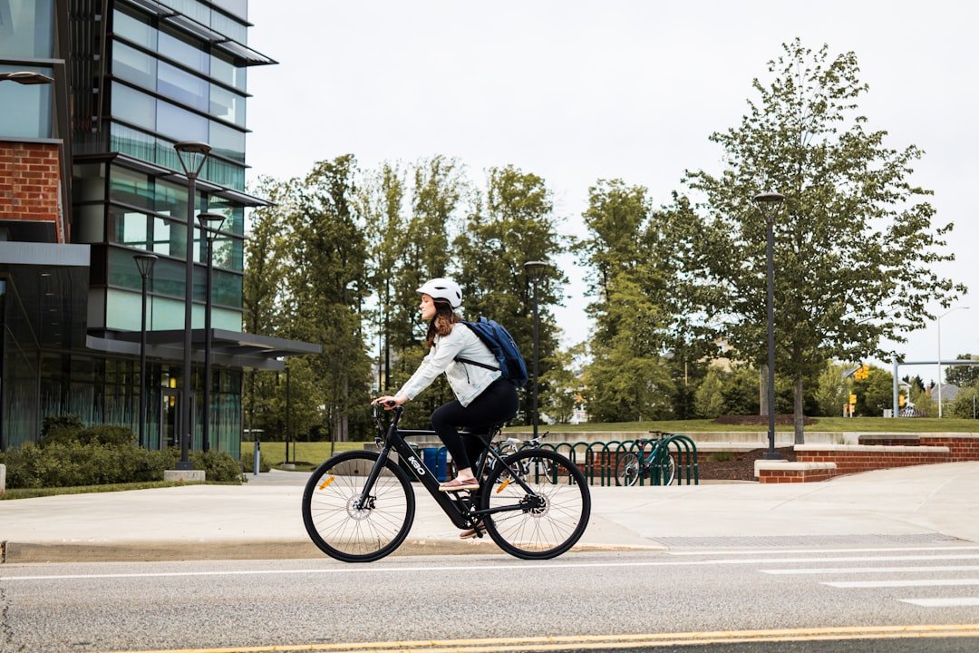 A person riding an electric bike through a green park, showcasing eco-friendly transportation.