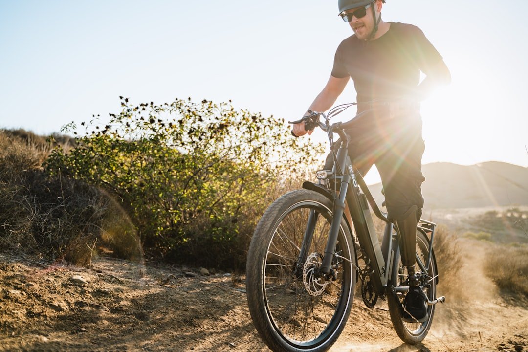 A cyclist riding an electric bike on a scenic path, showcasing speed and performance.