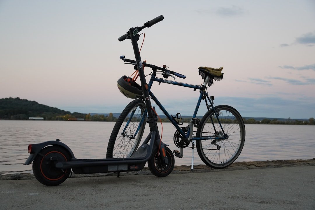 A side-by-side view of an electric bike and an electric scooter parked in an urban setting, showcasing their design and features.