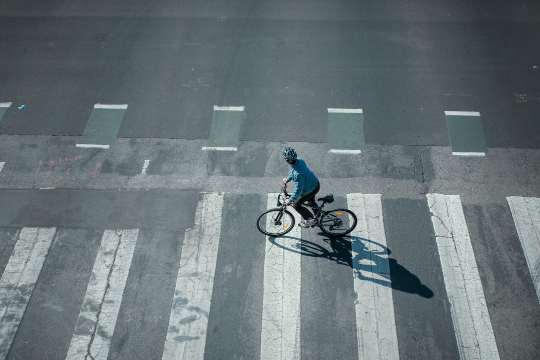 A cyclist riding an electric bike on a busy city street, showcasing safe riding practices in traffic.